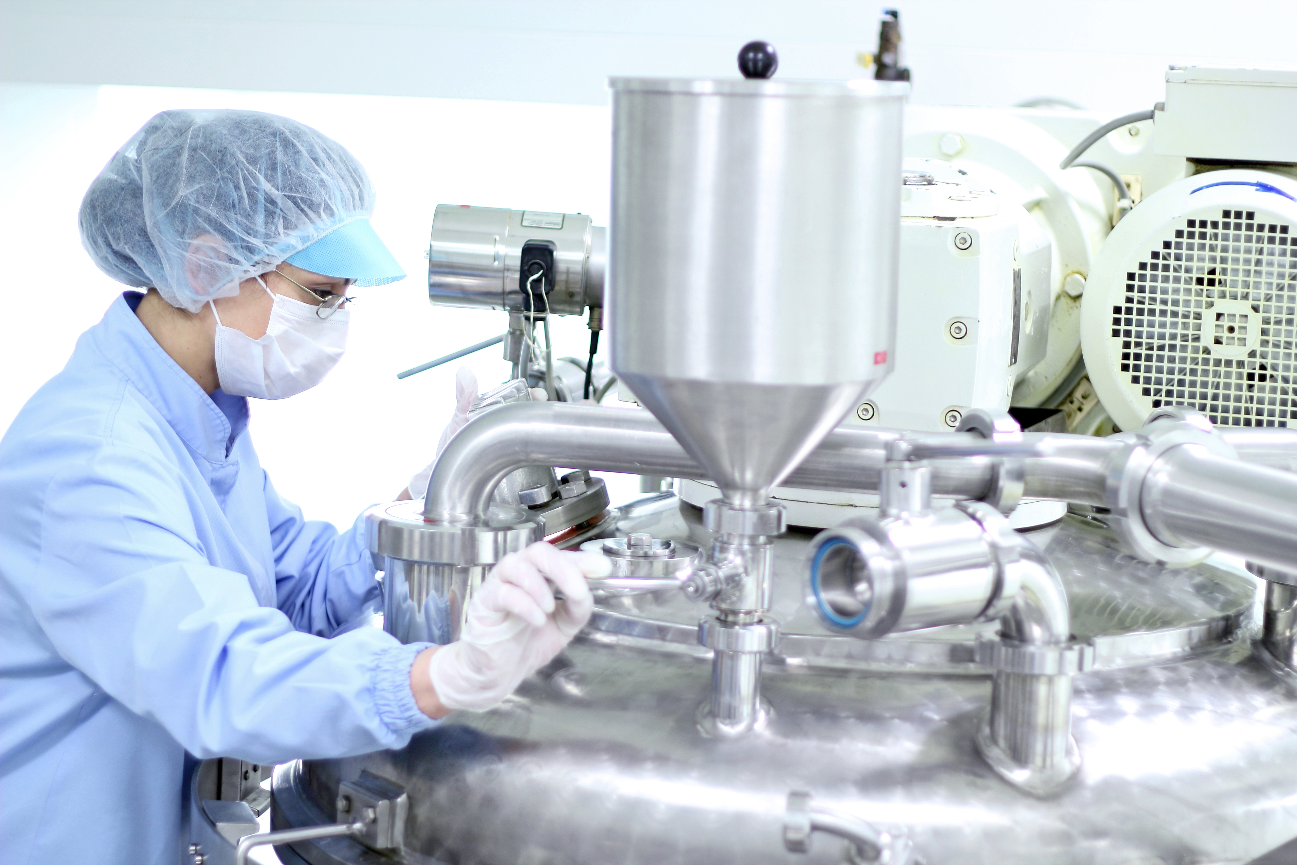 Pharmaceutical manufacturing professional examining equipment