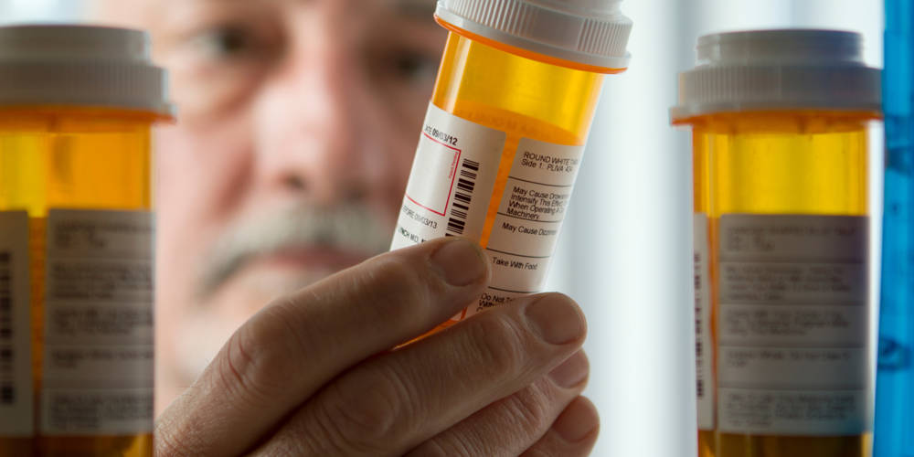 Man Reaching For Prescription Form Medicine Cabinet