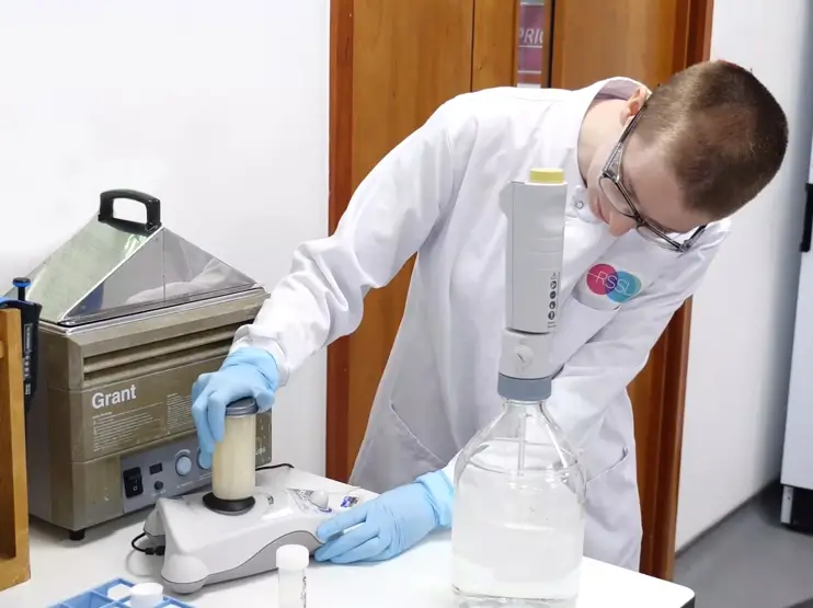 Scientist using a vortex mixer